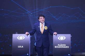 Candidato Renan Santos entre os púlpitos vazios de Lula e Flávio Bolsonaro, durante o debate na Band.