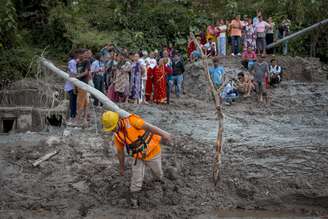 Moradores avaliam os danos após inundações repentinas ocorridas em 27 de agosto de 2026 em Trishuli, Nepal.