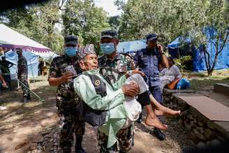 Militar carrega sobrevivente de inundações repentinas no Nepal