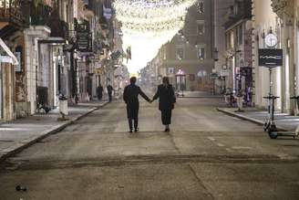 Casal caminha em rua vazia no centro de Roma durante lockdown pela pandemia de Covid, em 2021