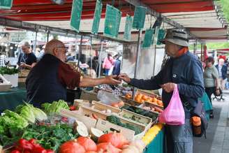 Cliente paga suas compras em uma banca de frutas e verduras em mercado local em Paris
10 de setembro de 2026. REUTERS/Stephanie Lecocq/Foto de arquivo