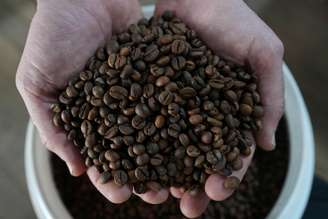 O cafeicultor Lucas Venturim segura grãos de café robusta na loja de sua fazenda em São Domingos do Norte, no estado do Espírito Santo, Brasil, em 23 de setembro de 2025. REUTERS/Alexandre Meneghini