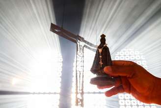 Devota segura imagem de Nossa Senhora de Aparecida na Basílica do Santuário Nacional de Aparecida, São Paulo, em 12 de outubro de 2023, em Aparecida, Brasil