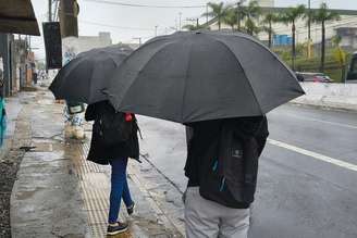 Pedestres se protegem da chuva na Avenida Interlagos, no Jardim Consórcio, zona sul de São Paulo, nesta sexta-feira, 2 de outubro de 2026