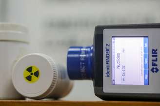 Profissional opera Instrumentos como Detector de radiação com sonda de contaminação.