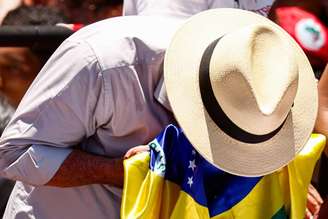 Lula beija a Bandeira do Brasil durante passeata em Ceilândia.