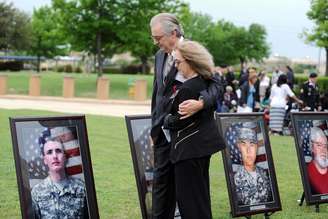 Pais de vítima do massacre de Fort Hood caminham entre fotos de militares mortos