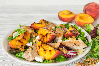 Salada de pêssego grelhado com frango, nozes e folhas verdes