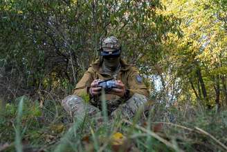 Militar ucraniano utilizando um controle remoto para pilotar um drone durante um exercício