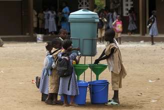Crianças lavam as mãos após a instalação para prevenir contágio de ebola em uma escola na Costa do Marfim