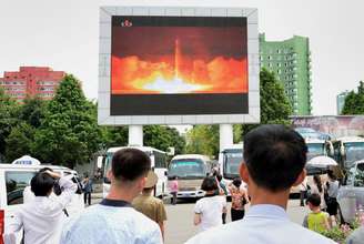 Pessoas observam reportagem sobre lançamento de míssil Hwasong-14 pela Coreia do Norte, na estação de Pyongyang 29/07/2017 Kyodo/via REUTERS