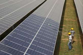 Trabalhadores limpam painéis de energia solar Gujarat, Índia 2,/7/2015 REUTERS/Amit Dave