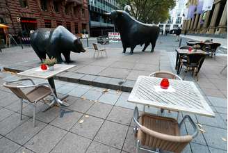 Mesas vazias em frente às estátuas do touro e do urso, símbolos dos períodos de alta e de baixa no mercado de ações. 29/10/2020. REUTERS/Ralph Orlowski