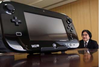 <p>Presidente da Nintendo, Satoru Iwata, é visto ao lado do controle do console Wii U</p>