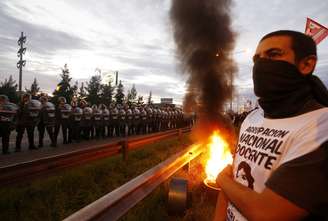 Manifestante fica próximo a policiais em protesto desta quinta-feira em rodovia Pan-Americana