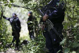 <p>Policiais montam guarda em uma área perto das fossas clandestinas em Pueblo Viejo, na periferia de Iguala, no estado mexicano de Guerrero, em 9 de outubro</p>