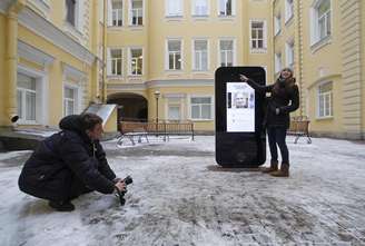 Homem tira foto de monumento em forma de iPhone para homenagear o fundador da Apple Steve Jobs em São Petersburgo. 10/01/2013