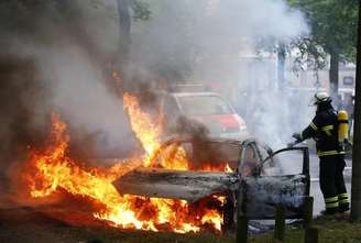 Bombeiro apaga chamas em carro em Hamburgo. 07/072017 REUTERS/Hannibal Hanschke T