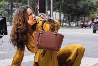 Zenilda durante cena em que é jogada por Arminda em direção aum ônibus 