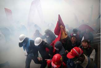 <p>Pessoas correm e se protegem, quando a polícia de choque usa canhões de água e gás lacrimogêneo para dispersar milhares de manifestantes que tentam chegar à principal praça de Istambul, a Taksim square, para celebrar o 1º de maio em Istambul, Turquia</p>