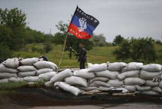 <p>Um ativista pró-Rússia regula o tráfego rodoviário em um posto de controle fora da cidade ucraniana oriental de Druzhkovka, em 2 de junho</p>