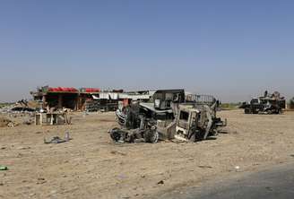 <p>Veículos queimados pertencentes às forças de segurança iraquianas são vistos em uma estrada que leva a Samarra, na província de Salahuddin, em 12 de julho</p>