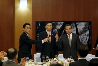 <p>Chanceler sul-coreano, Yun Byung-se, o japonês, Fumio Kishida, e o chinês, Wang Yi, brindam durante banquete em Seul, neste sábado (21)</p>