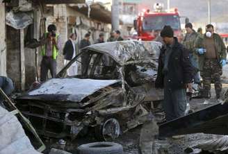 Policiais do Afeganistão examinam local do ataque suicida com carros-bomba em Cabul 10/04/ 2015.