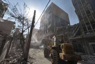 Um carregador trabalha no local de prédios residenciais destruídos devido aos ataques israelenses em Teerã, Irã, em 13 de junho de 2025.