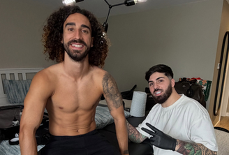 Cucurella ao lado do tatuador que fez o desenho do treinador em seu braço