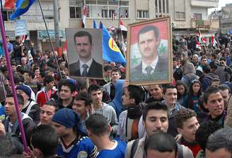 <p>Líderes têm buscado solução para a guerra civil no país, que já dura três anos. Na foto, de 11 de fevereiro, partidários do presidente sírio, Bashar al-Assad, participam de marcha em apoio ao governo, na cidade de Homs, Síria</p>