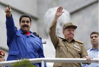 Com seu uniforme de general, Raúl Castro, com Maduro a seu lado, saudou milhares de pessoas que marcharam diante de uma tribuna na Praça da Revolução