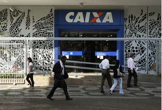 Pessoas passam pela frente de agência da Caixa Econômica Federal, no Rio de Janeiro. 20/8/2014. REUTERS/Pilar Olivares 