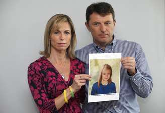 Os pais da menina, Kate e Gerry McCann, posam com a foto de Madeleine em 2 de maio de 2012