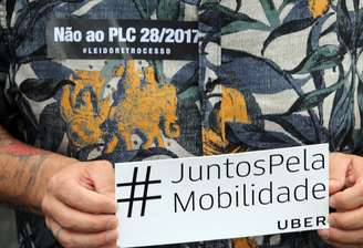 Motorista do Uber segura cartaz de protesto durante manifestação contra projeto de lei em São Paulo, Brasil 
30/10/2017 REUTERS/Paulo Whitaker