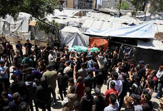 Pessoas carregam um corpo identificado por pessoas de luto como o comandante da ala militar do Hamas, Izz al-Din al-Haddad, que foi morto em um ataque israelense na sexta-feira, durante um funeral, na Cidade de Gaza, em 16 de maio de 2026. REUTERS/Dawoud Abu Alkas