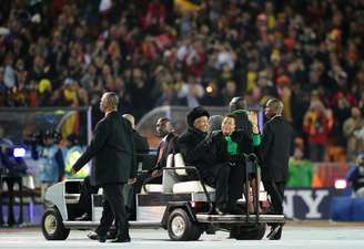 Mandela e a sua mulher, Graça Machel, acenam ao chegarem para cerimônia de encerramento da Copa do Mundo de 2010 no estádio Soccer City, em Soweto, em 11 de julho