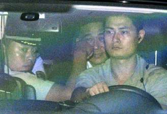 Bo Xilai, no banco de trás, deixa a corte em carro com pioliciais