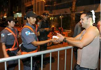 <p>Manifestantes oferecem pedaços de bolo a policiais em um protesto perto da casa de Sérgio Cabral</p>