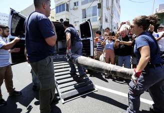 <p>Policiais especialistas em explosivos carregam os restos de um foguete em uma van, depois de o mesmo ter sido interceptado pelo sistema de defesa aérea de Israel "Iron Dome", em Tel Aviv, nesta sexta-feira, 11 de julho</p>