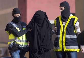 Policiais mascarados espanhóis prendem uma mulher suspeita de participar de uma organização que recrutava mulheres para os jihadistas do Estado Islâmico