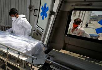 Profissional de saúde coloca corpo de homem que morreu de Covid-19 em ambulância em hospital de Ahmedabad, na Índia
14/04/2021 REUTERS/Amit Dave