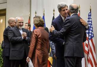 O chanceler iranino, Javad Zarif, sorri ao cumprimentar a chefe de relações exteriores da UE, Catherine Ashton, enquanto o secretário de Estado dos EUA, John Kerry, cumprimenta o chanceler francês, Laurent Fabius