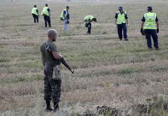 <p>Separatista pró-Rússia acompanha trabalho de especialistas de missão de recuperação no local da queda de voo MH17 no leste da Ucrânia</p>