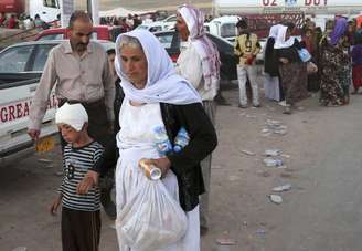 <p>Iraquianos deslocados da comunidade Yazidi chegam ao acampamento de Bajid Kandala em Feeshkhabour, cidade perto da fronteira com a Síria, no Iraque, no sábado, 9 de agosto</p>