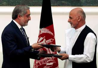 <p>Candidatos presidenciais rivais Abdullah Abdullah (à esquerda) e Ashraf Ghani trocam acordos assinados para o governo de unidade afegão, em Cabul, em 21 de setembro </p>