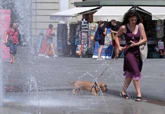 Mulher se refresca do calor em fonte em Turim, norte da Itália