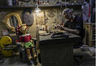 Escultor Stanislav Deryabin e o boneco Pinóquio em seu ateliê em Nizhny Tagil, na Rússia