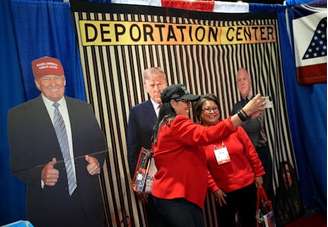 Participantes tiram selfies com imagens de Trump na Conferência de Ação Política Conservadora (CPAC): para observadores externos, afirmação de uma nova "era de ouro" pode parecer estranha, mas para partidários do presidente americano sua própria volta ao poder já é um sinal disso Andrew Harnick/Getty Images