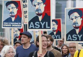 <p>Manifestantes seguram cartazes durante protesto em apoio a Edward Snowden, em Berlim</p>